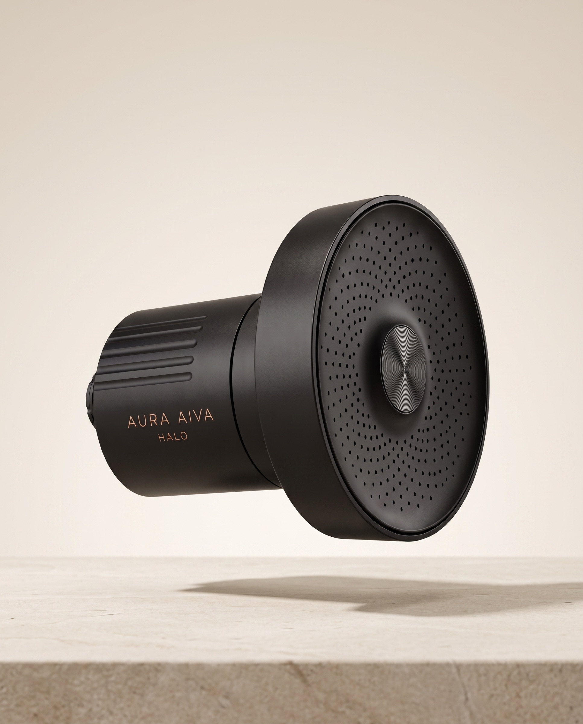 The Aura Aiva Halo filtered shower system in Matte Black on a stone ledge